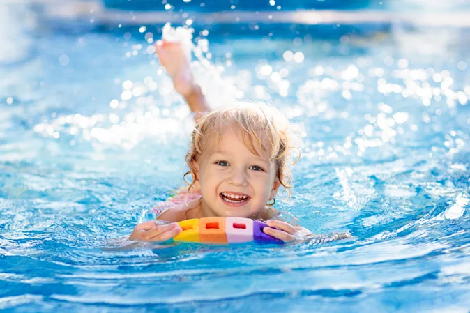 What does a toddler wear while swimming on summer vacation? image