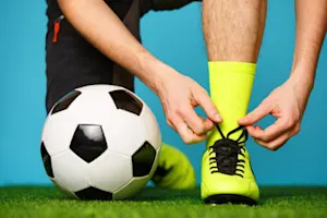 Why did the footballer hold his boot to his ear? image